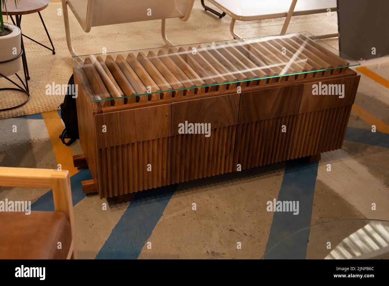 Une petite commode horizontale en bois dans une pièce avec du verre sur le dessus pour dîner Banque D'Images
