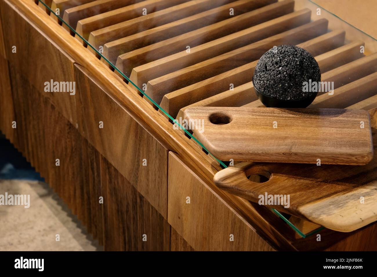 Une boule de granit noir sur le verre d'une petite commode en bois Banque D'Images