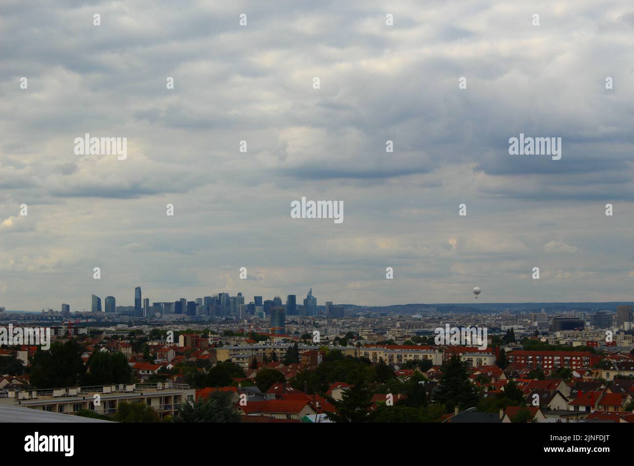 Horizon de Paris vu de Châtillon lors d'une journée nuageux avec une montgolfière dans le ciel. Horizon de Paris en été, paysage urbain Banque D'Images