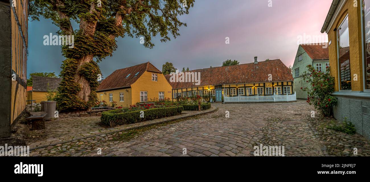 La petite ville de Mariager et l'hôtel Postgaarden à colombages sur la place pavée dans la lumière rose du soleil couchant, Mariager, Danemark, août Banque D'Images