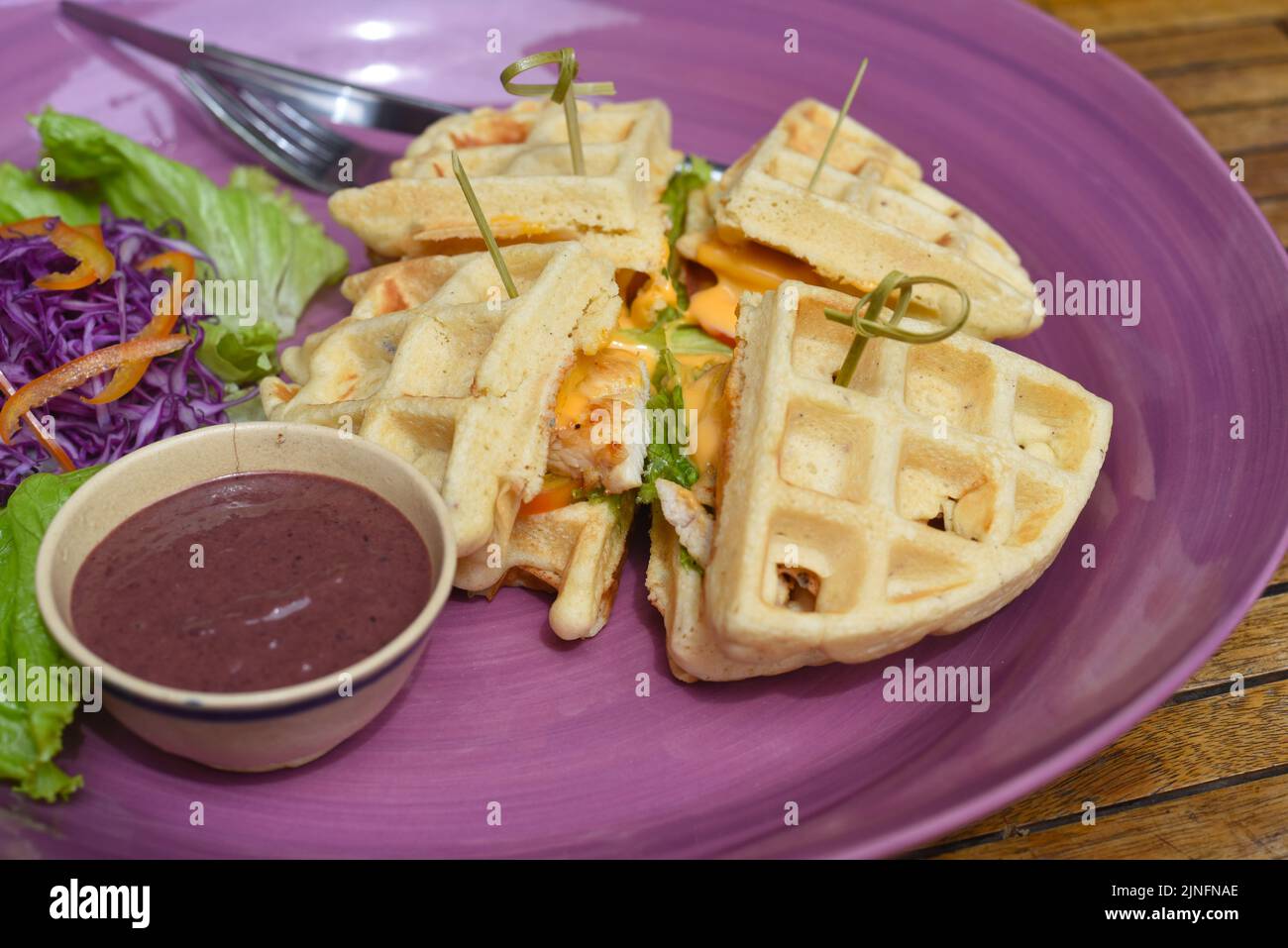 Gaufres belges avec poulet poêlé sur une assiette mauve Banque D'Images