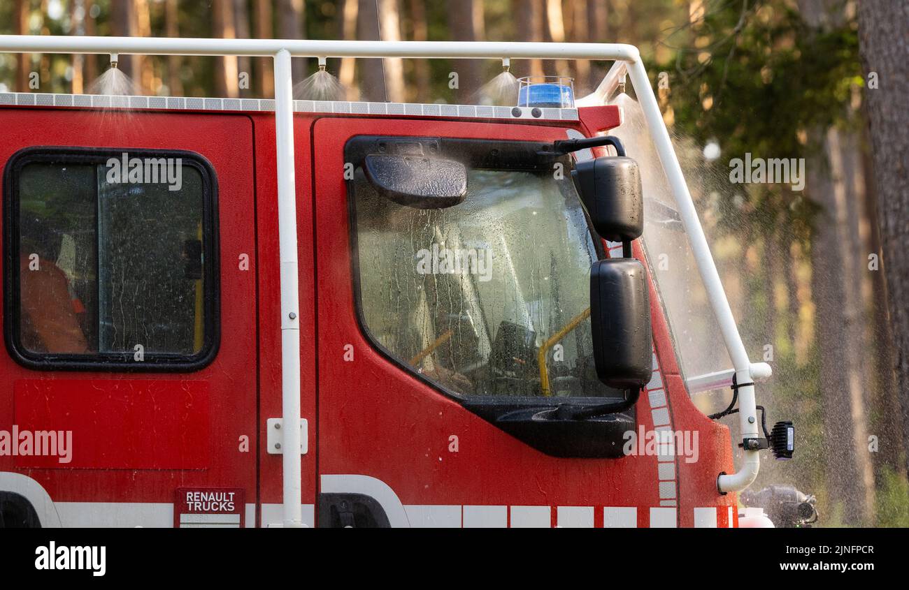 Wietzendorf, Allemagne. 09th août 2022. Les pompiers volontaires testent le système d'auto-protection du camion-citerne « CCFM 3000 » au cours d'un exercice. Le 'CCFM 3000' est un véhicule hautement spécialisé pour lutter contre les feux de végétation qui est également adapté aux défis particuliers des opérations dans d'autres pays européens. La Basse-Saxe soutient la lutte contre les incendies de forêt dans la région sud-française de la Gironde avec deux de ces véhicules spéciaux et du personnel. (À dpa 'la Basse-Saxe soutient la lutte contre les incendies de forêt dans le sud de la France') Credit: Philipp Schulze/dpa/Alamy Live News Banque D'Images