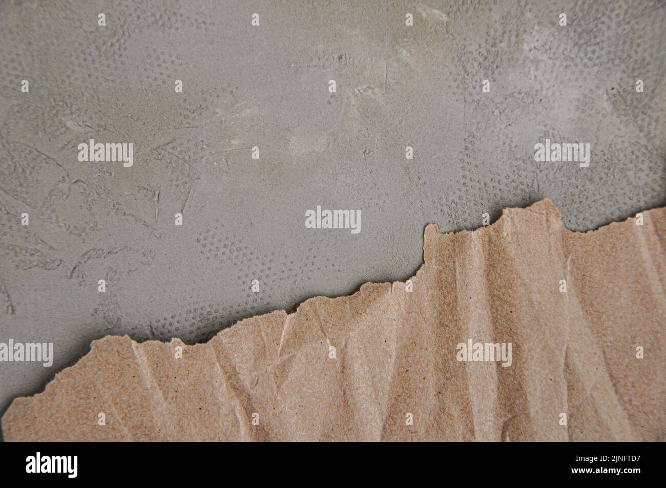 Papier brun froissé avec bords déchirés, fond gris, texture du papier artisanal Banque D'Images