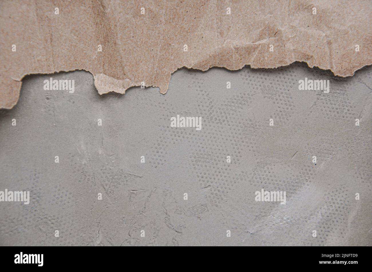 Papier brun froissé avec bords déchirés, fond gris, texture du papier artisanal Banque D'Images