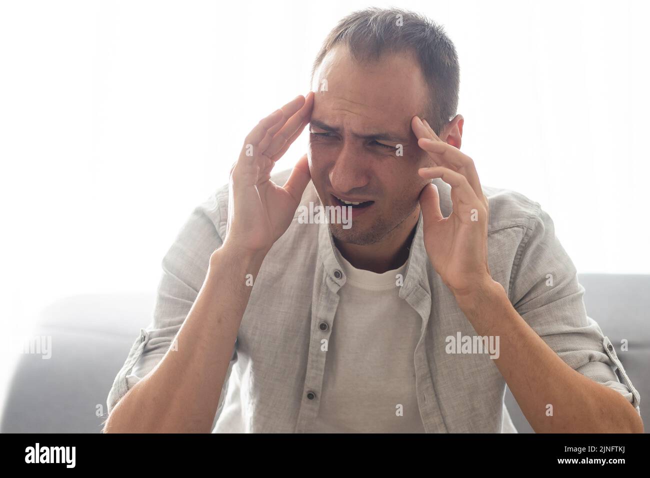 Exténué travailleur du millénaire caucasien prendre des lunettes de massage les yeux souffrent de maux de tête ou de migraine, l'homme fatigué se sentent la fatigue submergée par Banque D'Images