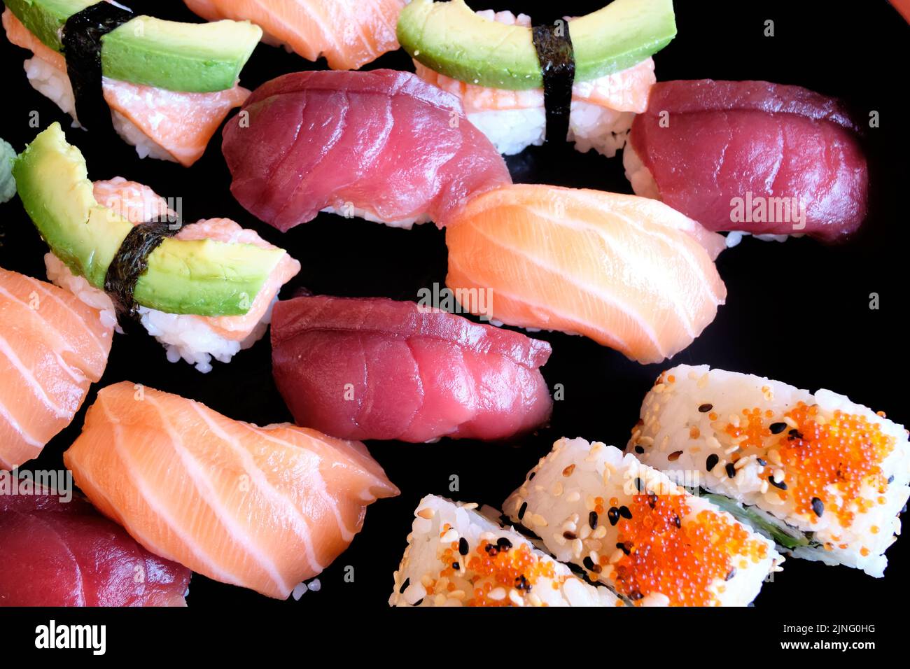 Sushi japonais. Maki et petits pains au thon, au saumon, aux crevettes, au crabe et à l'avocat. Vue de dessus de l'assortiment de sushis. Rouleau de sushis arc-en-ciel, uramaki, hosoma Banque D'Images