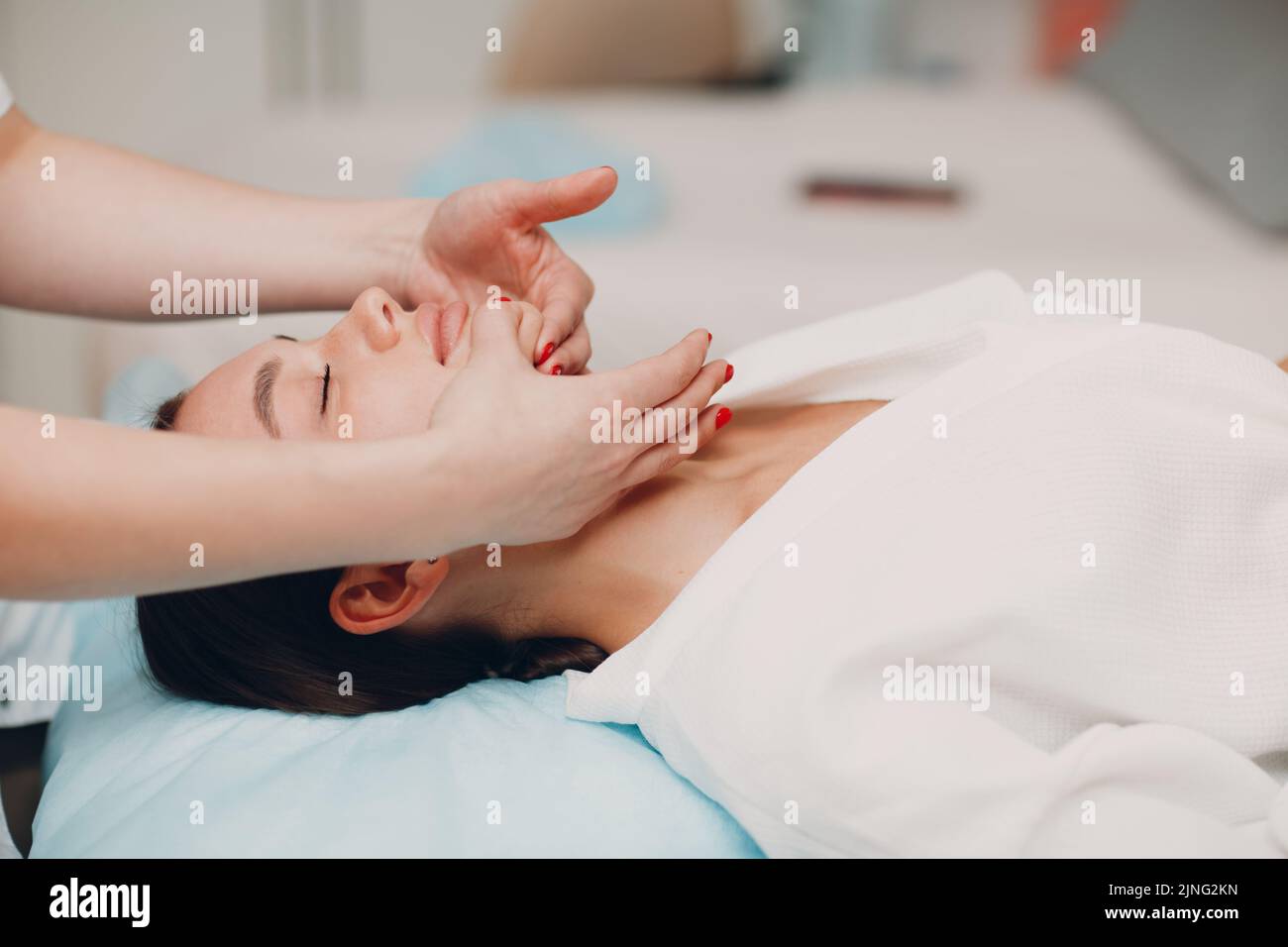 Belle jeune femme recevant un massage de soin du visage au spa de beauté Banque D'Images