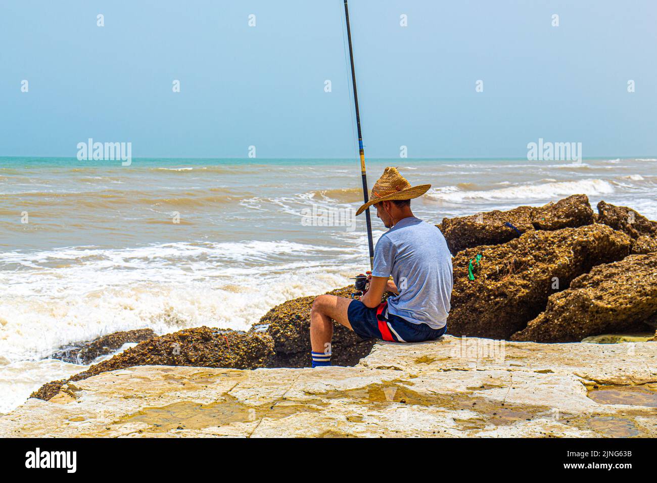 Un Fisher tenant son crochet avec sa tige de pêcheur avec un beau coucher de soleil dans la ville de Laayoune Banque D'Images Un Fisher tenant son crochet avec sa tige de pêcheur avec un beau coucher de soleil dans la ville de Laayoune Banque D'Images