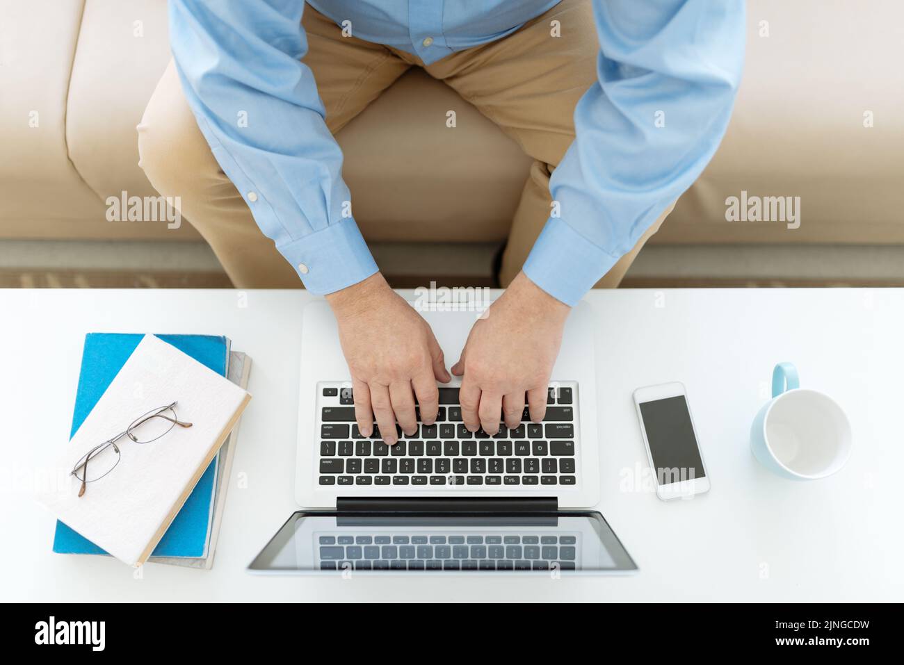 Homme senior travaillant sur un ordinateur portable, vue du dessus Banque D'Images