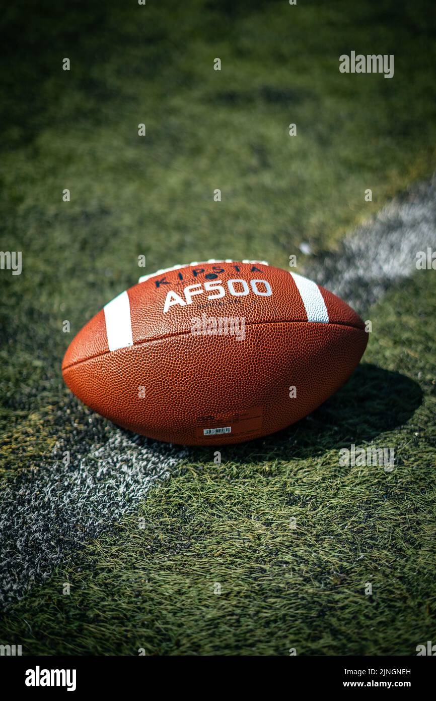 Gros plan vertical d'un ballon de football américain kipsta AF500 sur un terrain synthétique Banque D'Images