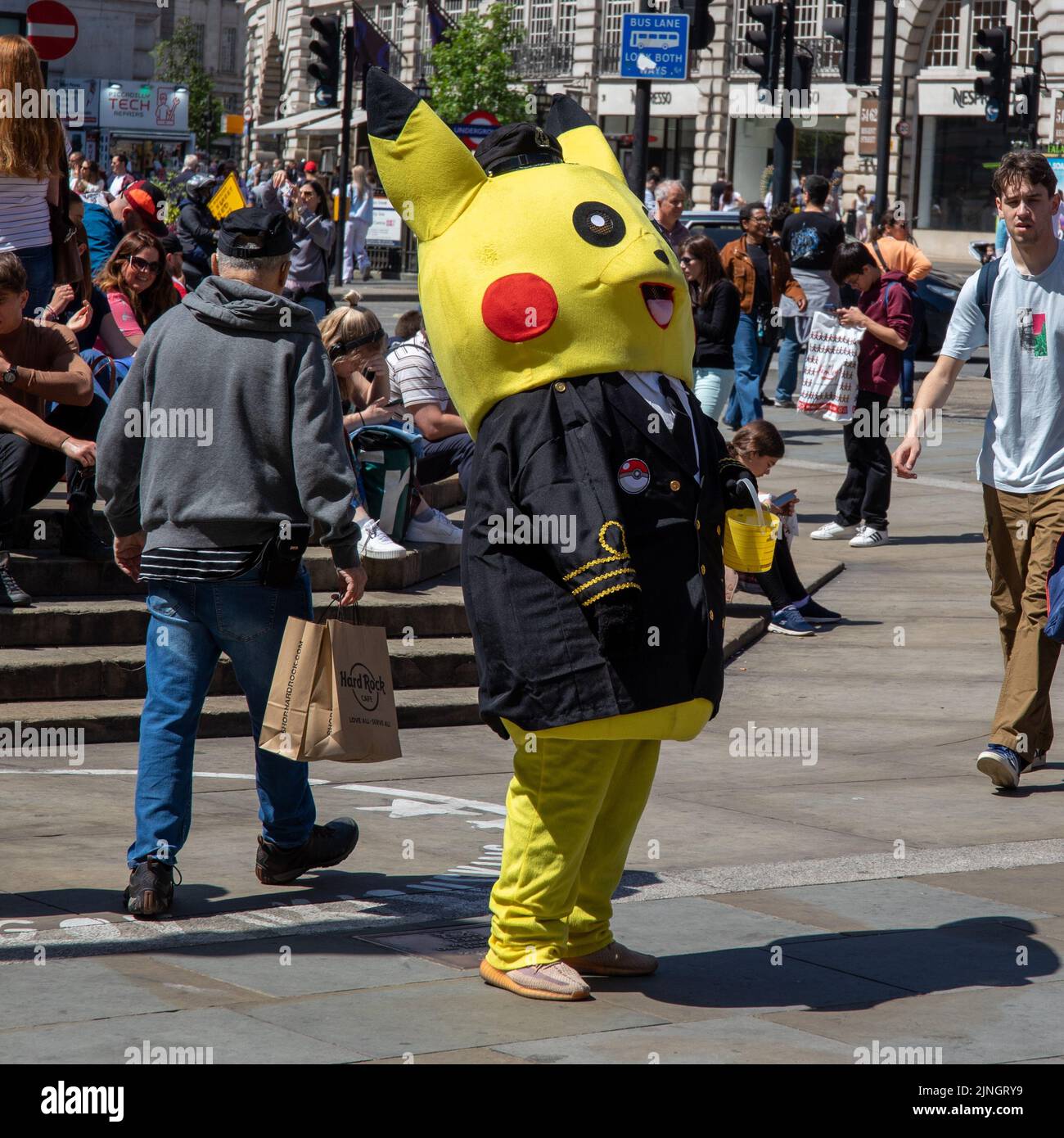 Un homme debout à Picadilly Circus portant un costume Pokemon Pikachu à Londres, Royaume-Uni Banque D'Images