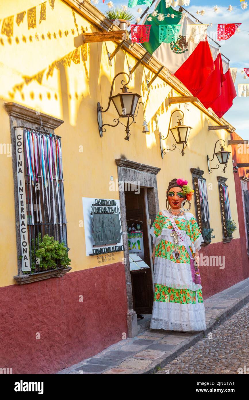 Un mojiganga, ou marionnette géante faite de papier mâché se tient à l'extérieur d'un restaurant pour attirer l'attention dans le centre-ville historique de San Miguel de Allende, Mexique. Banque D'Images