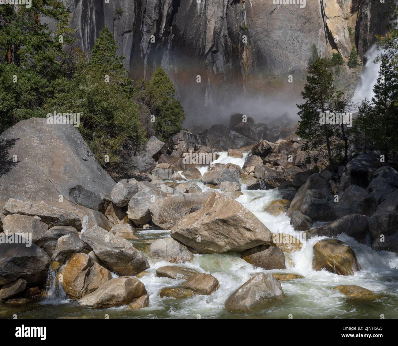 Rocky creek menant à Bridalveil de Yosemite chute de près au printemps de 2022, Californie, États-Unis, y compris une pointe d'un arc-en-ciel Banque D'Images