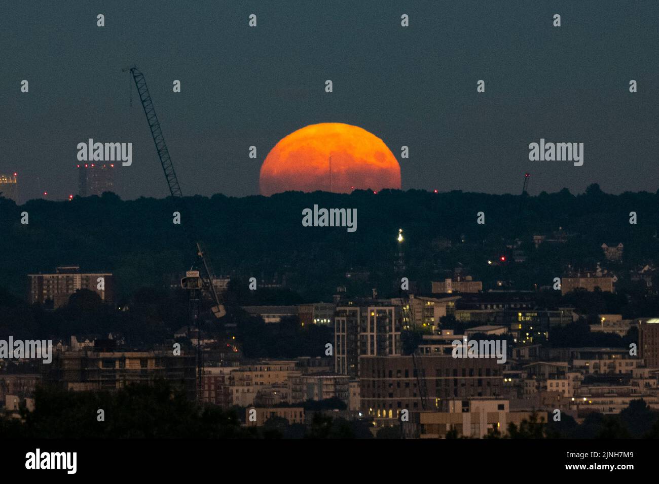 Londres, Royaume-Uni. 11 août 2022. Météo au Royaume-Uni – la pleine lune d'août s'élève au-dessus des gratte-ciel de la capitale. Il sera plus complet à 02:35 le 12 août. On l’appelle la Lune de l’esturgeon selon l’Almanac du Vieux-agriculteur en raison du grand nombre de poissons d’esturgeon qui ont été trouvés dans les Grands Lacs en Amérique du Nord à cette époque de l’année. La pleine lune d’août est également connue sous le nom de « super lune », qui paraîtra plus lumineuse et plus grande, car elle sera à son point le plus proche de la Terre dans son orbite, connue sous le nom de périgée. Credit: Stephen Chung / Alamy Live News Banque D'Images
