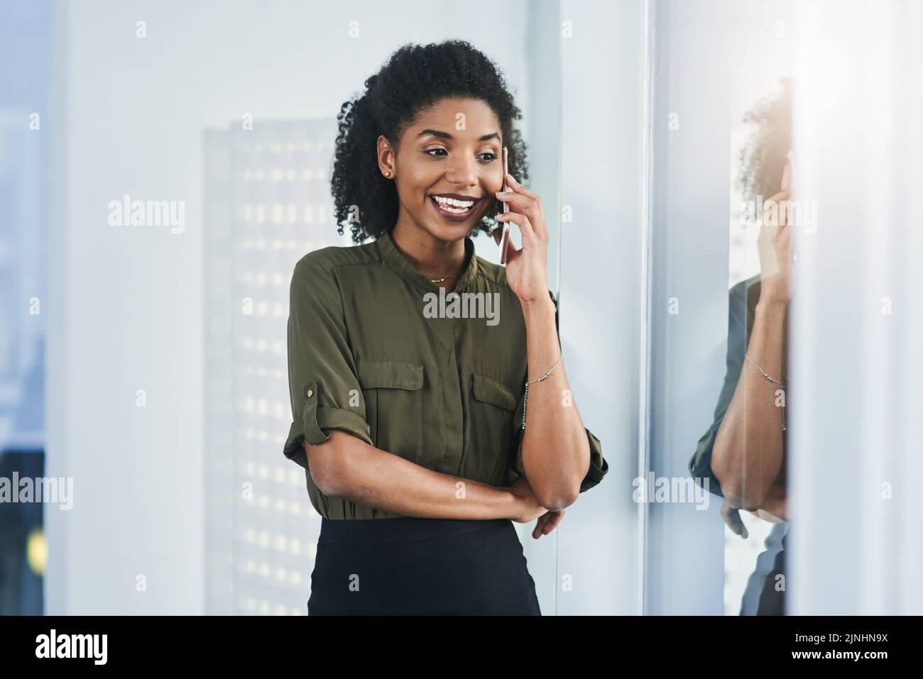 Gardez toujours une oreille à l'extérieur pour ce qui vous arrive. Une jeune femme d'affaires qui fait un appel téléphonique dans son bureau. Banque D'Images
