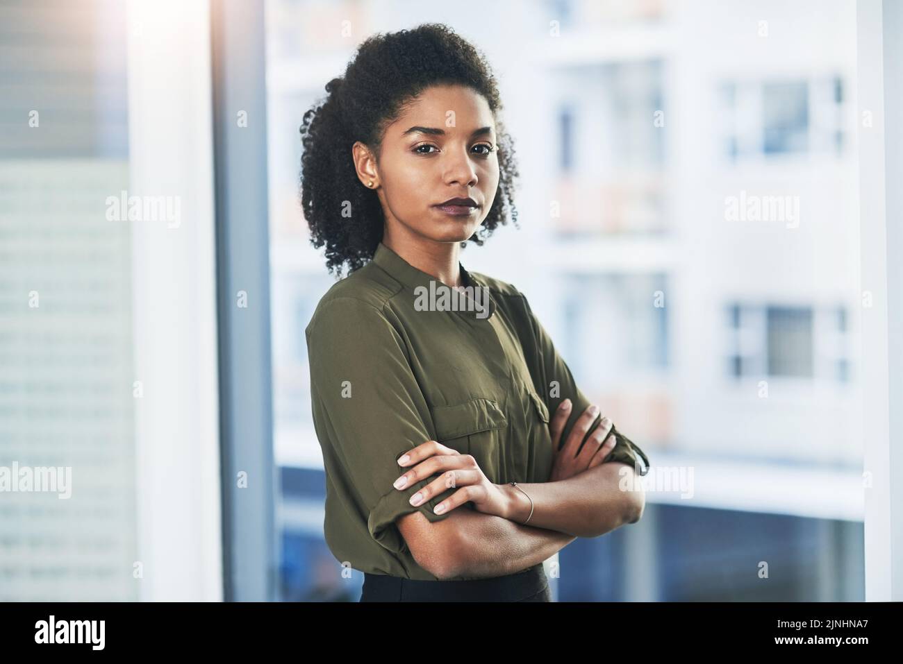 Le succès est une mentalité, pas un exploit réalisé sur la chance. Portrait d'une jeune femme d'affaires debout dans son bureau avec ses bras pliés. Banque D'Images