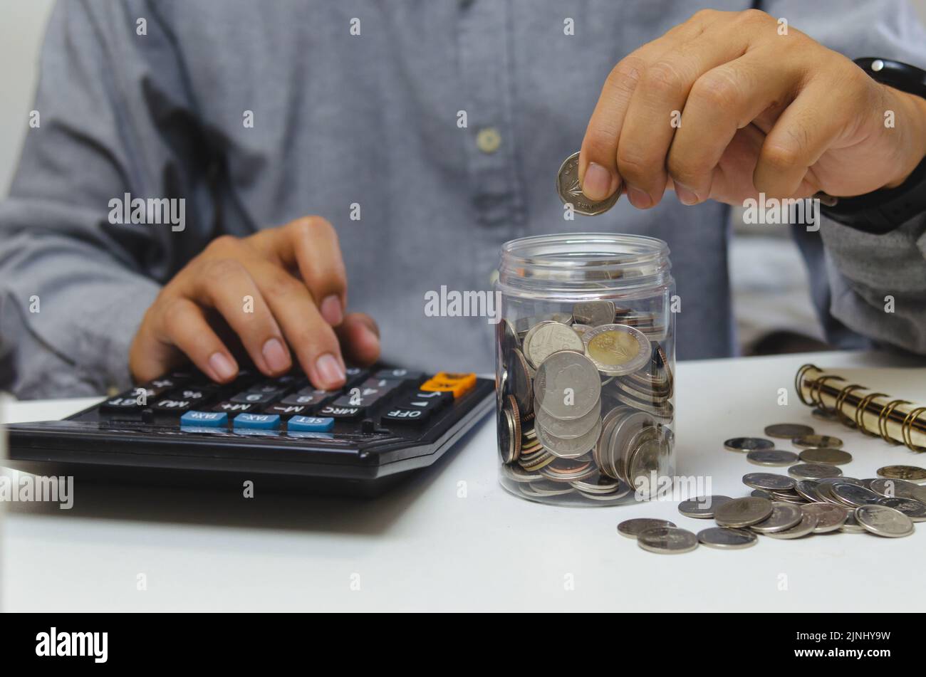 homme d'affaires utiliser la calculatrice argent pièce de monnaie impôt financier et de planification investissements marketing économie revenu et épargne-retraite. Banque D'Images