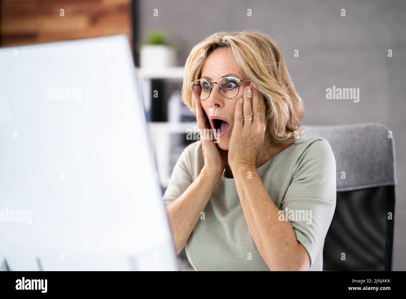Femme d'affaires frustrée regardant son écran d'ordinateur dans la consternation Banque D'Images