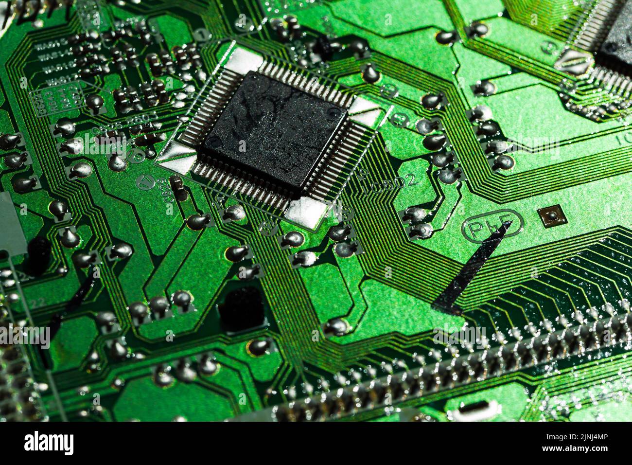 Circuit imprimé vert avec micropuce et condensateurs, gros plan avec mise au point sélective Banque D'Images