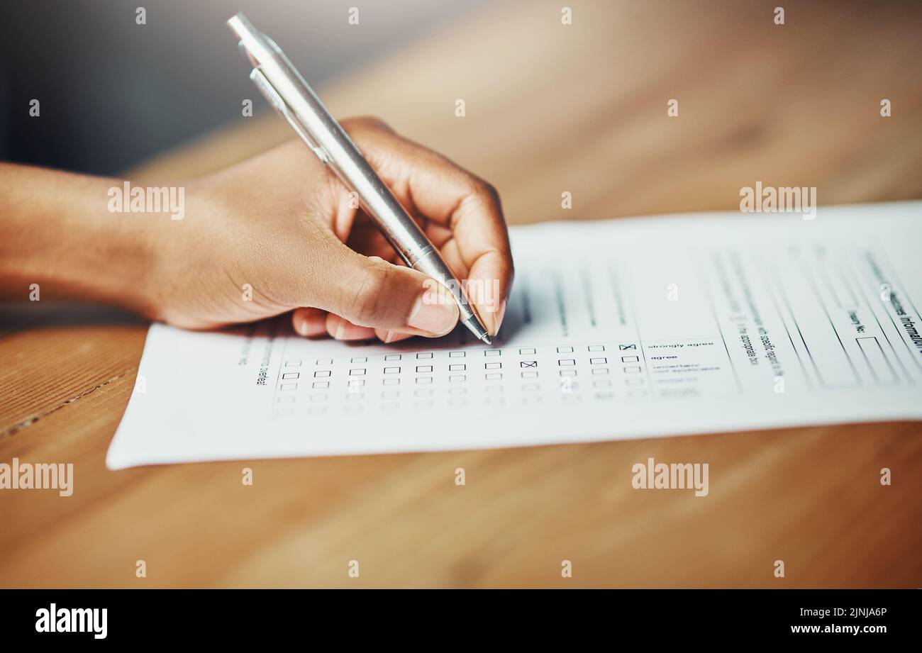 Son opinion compte. Gros plan d'une femme qui dépose la main dans les documents administratifs pour une demande ou un sondage officiel. Une femme écrivant sur un formulaire demandant un Banque D'Images