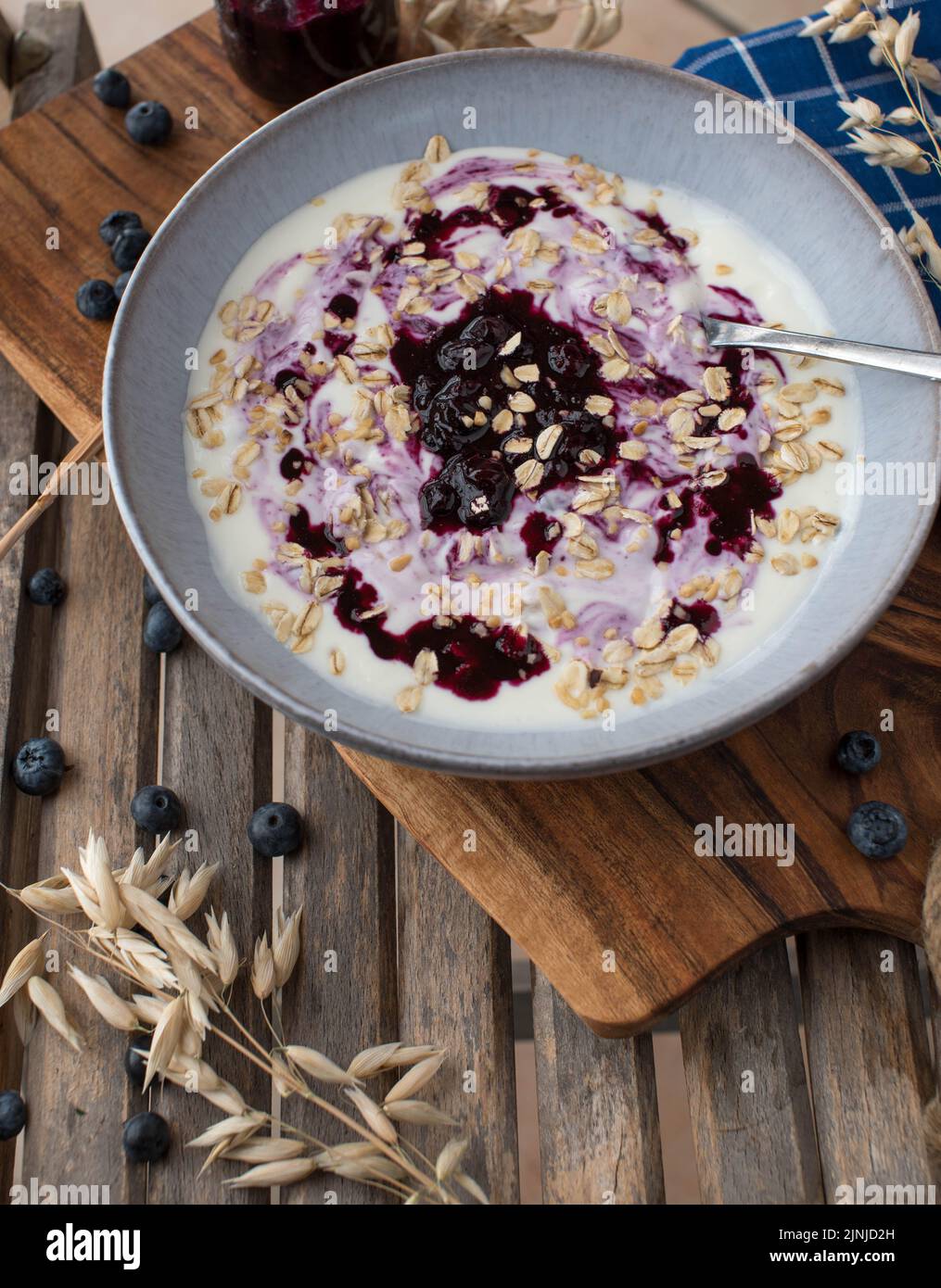 Petit-déjeuner avec yaourt, compote de myrtille et avoine dans un bol sur fond de bois Banque D'Images