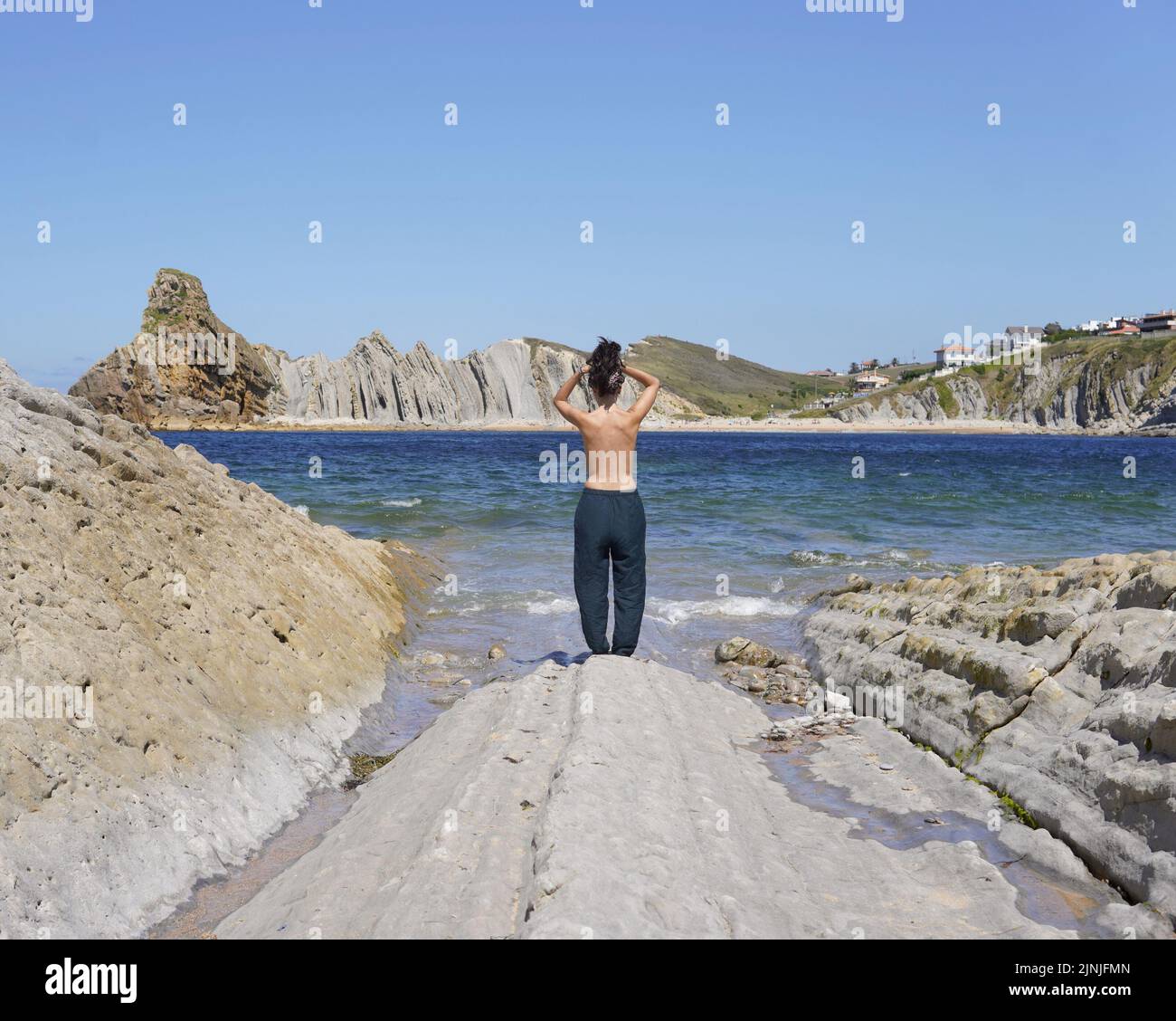Femme de derrière dans une plage de costa Quebrada, Liencres, Cantabrie en Espagne Banque D'Images