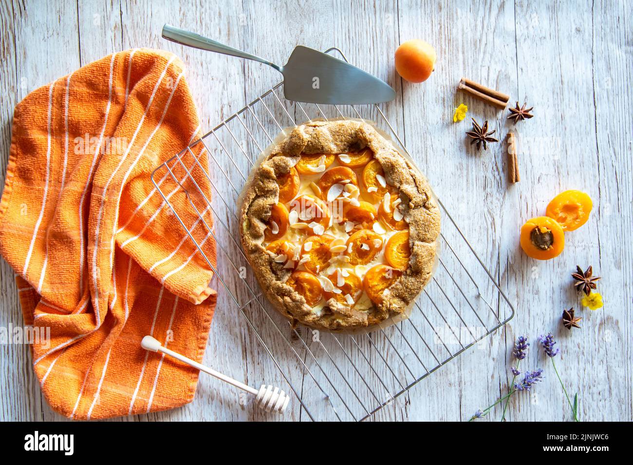 Gâteau à tarte à la galette d'abricot placé sur fond de bois avec des outils de cuisson sur le côté Banque D'Images