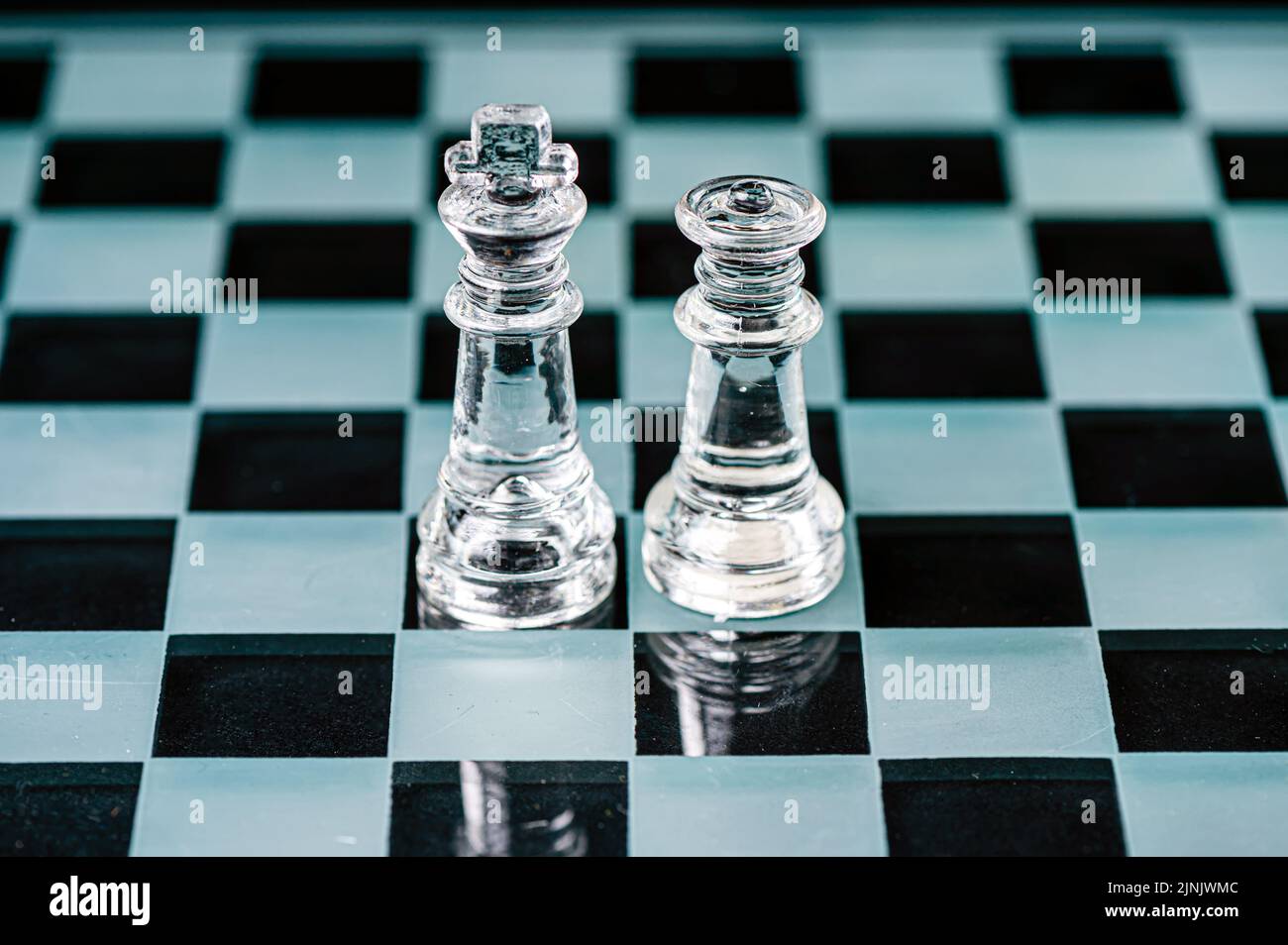 roi et reine sur le plateau d'échecs, macro image de pièces de verre. dof peu profond, mise au point sélective Banque D'Images