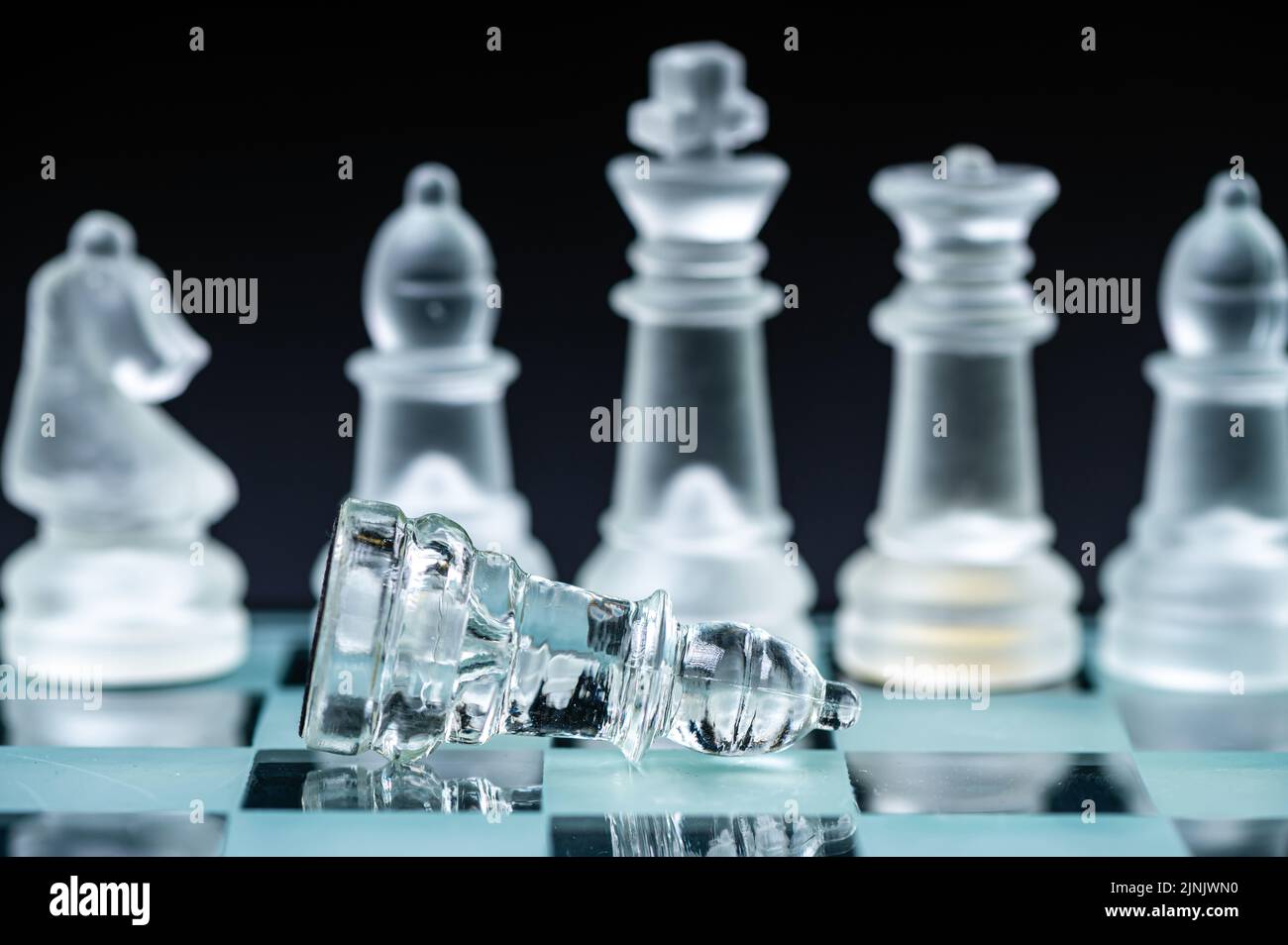 verre transparent, pièces d'échecs transparentes sur un damier, mise au point sélective, gros plan, isolé sur le noir Banque D'Images