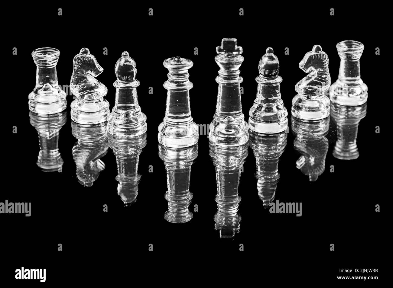 jeu d'échecs en verre transparent sur fond noir, mise au point sélective sur les pièces du roi et de la reine, gros plan Banque D'Images