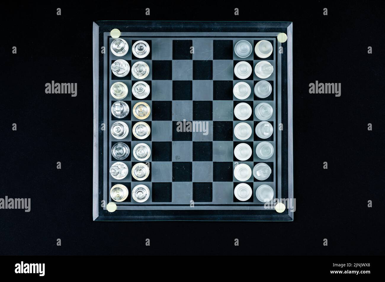 Ensemble de pièces d'échecs en verre transparent sur noir, mise au point sélective, espace de copie, vue de dessus Banque D'Images