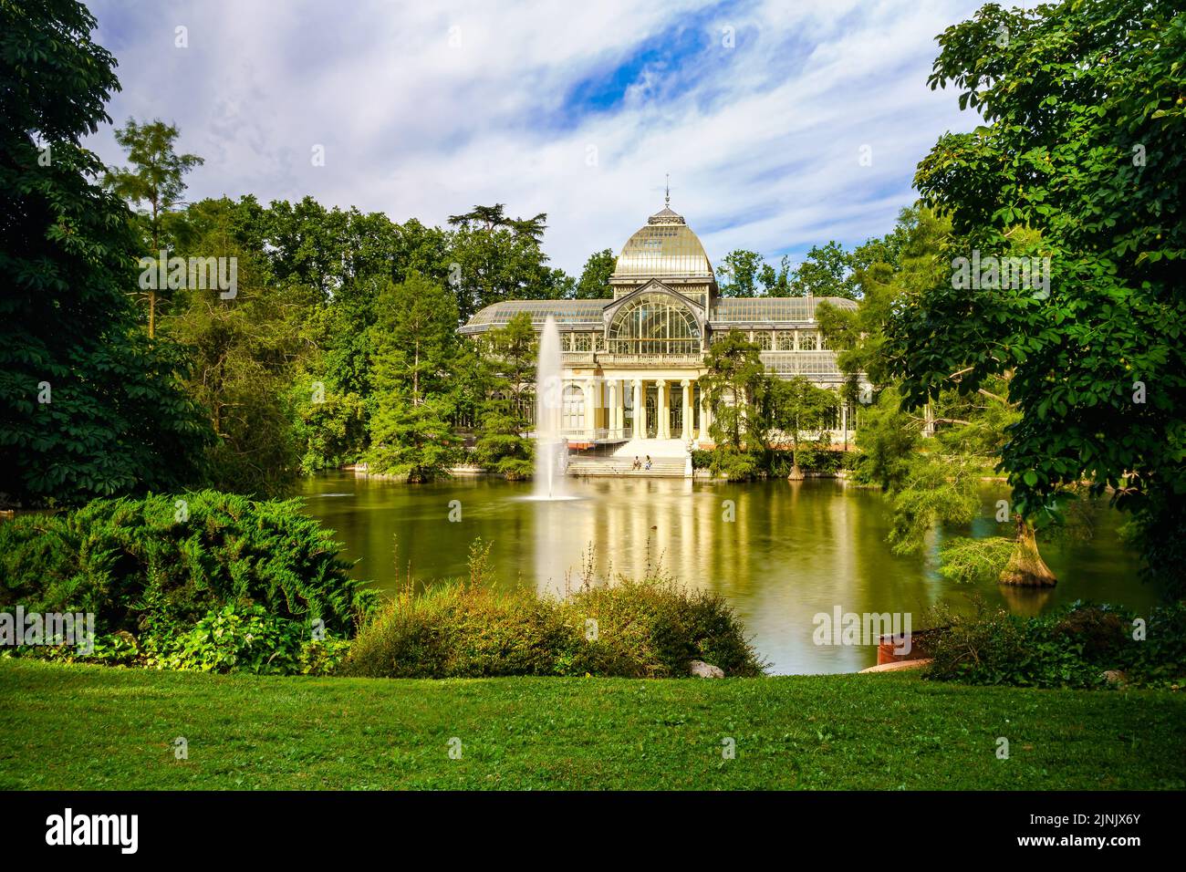 Palacio de Cristal dans le parc public du Retiro de Madrid avec son lac sur la façade principale. Banque D'Images