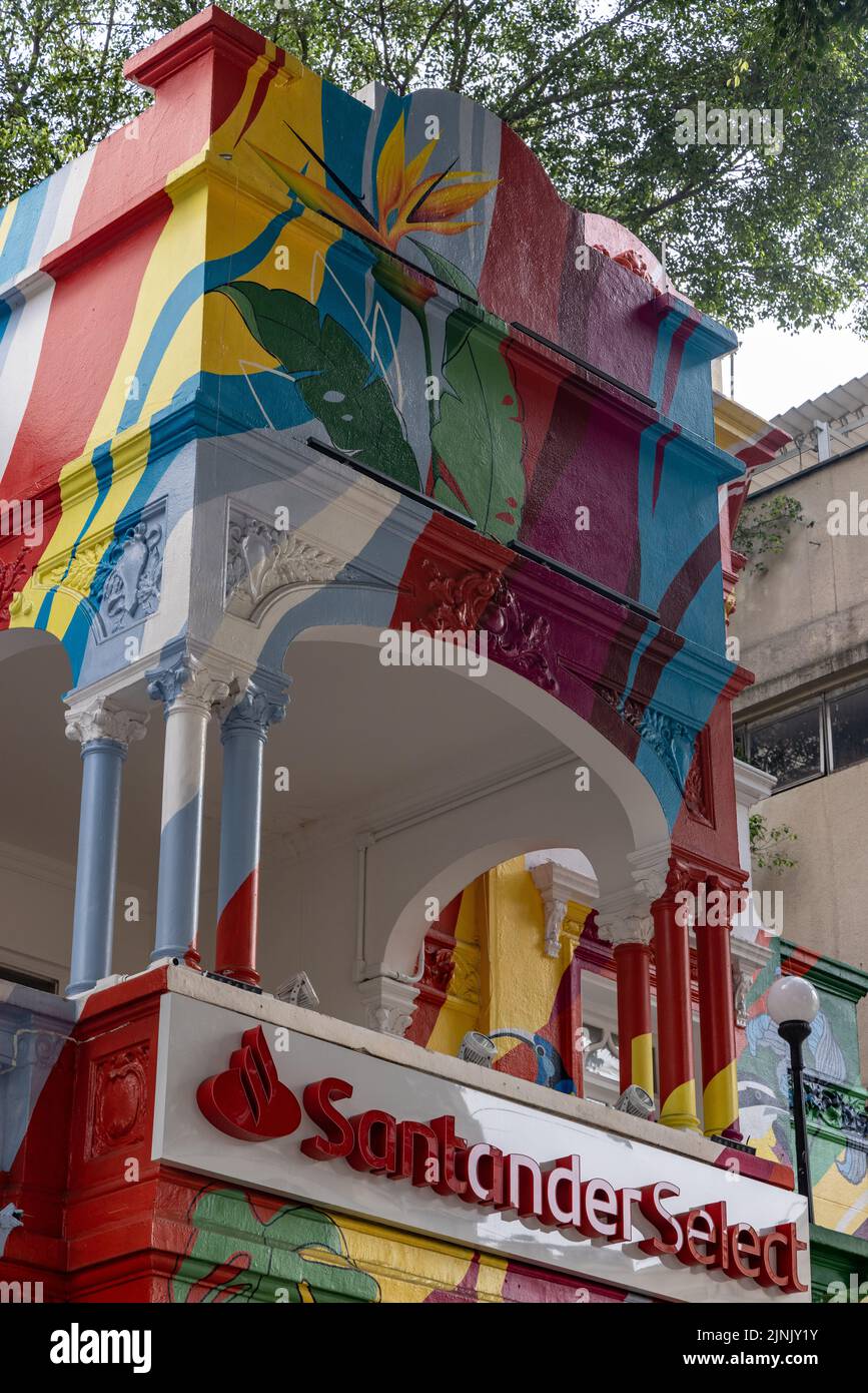 Vue sur la façade d'un bâtiment coloré avec un panneau Santander Select Banque D'Images