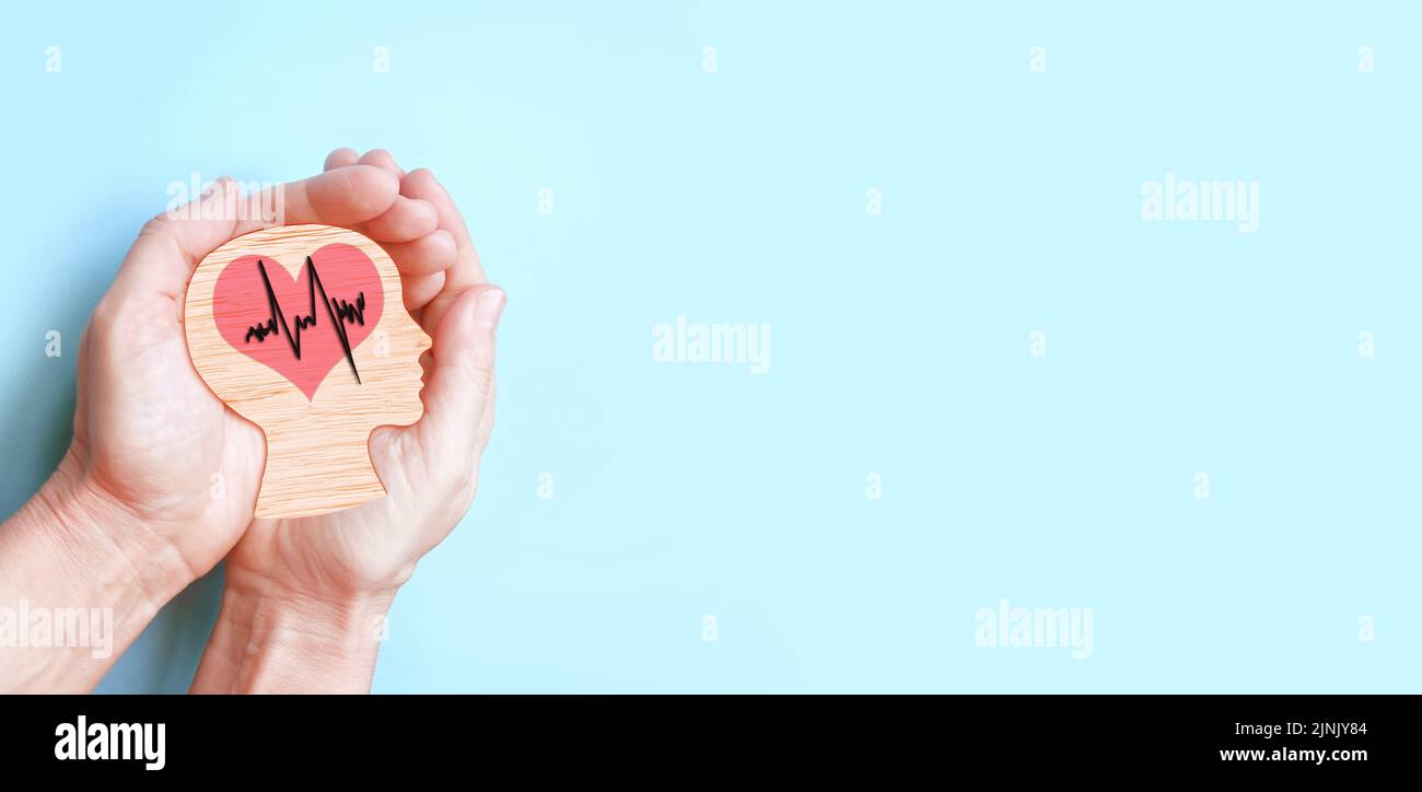 Mains tenant le cerveau et le coeur en bois, accident vasculaire cérébral, journée mondiale du coeur, journée mondiale de la santé mentale, concept Alzheimer. Banque D'Images
