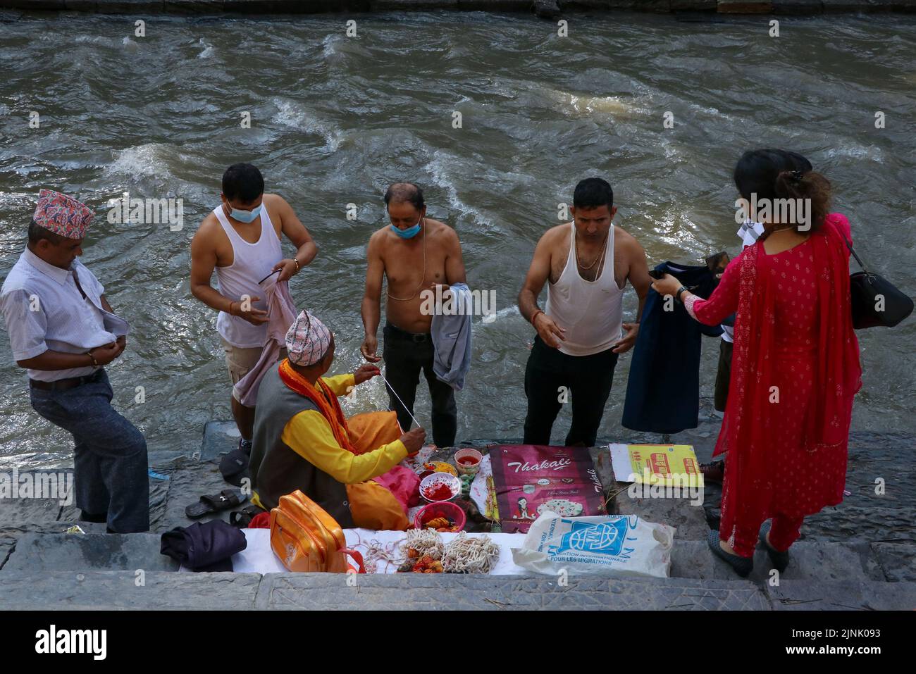 Les dévotés et un prêtre exécutent un rituel culturel à la banque de la rivière bagmati marquant le festival Janai Purnima qui est également appelé le festival du fil sacré à Katmandou, au Népal, le 12 août 2022. (Photo de Abhishek Maharajan/Sipa USA) Banque D'Images