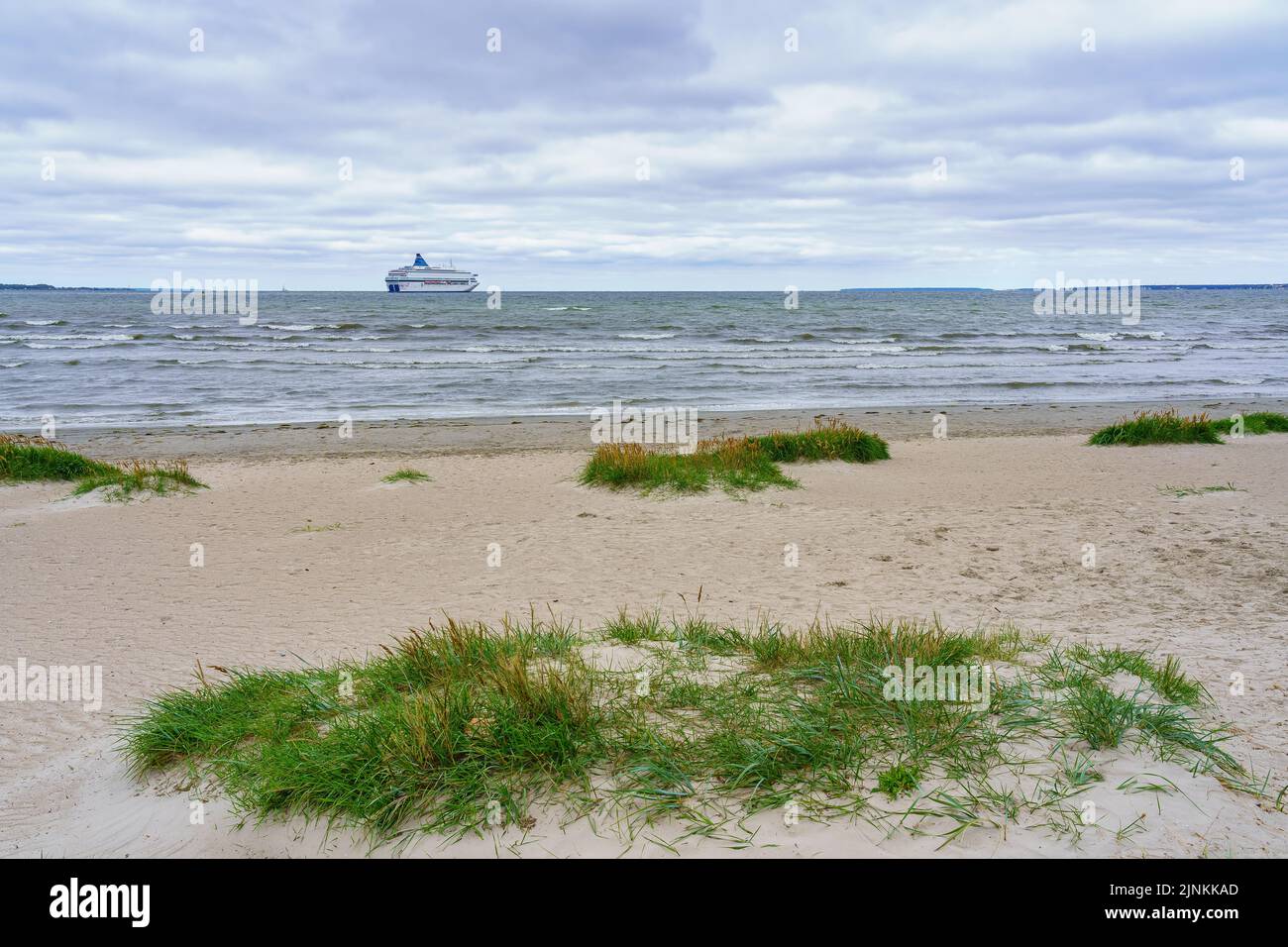 Super ferry qui se perd au-dessus de l'horizon de la mer sur une plage déserte. Banque D'Images