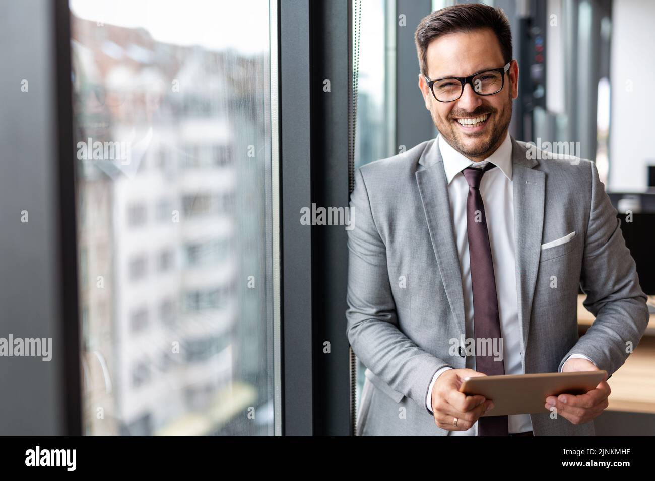 Portrait d'un jeune homme d'affaires avec succès avec une tablette numérique dans un bureau d'entreprise Banque D'Images