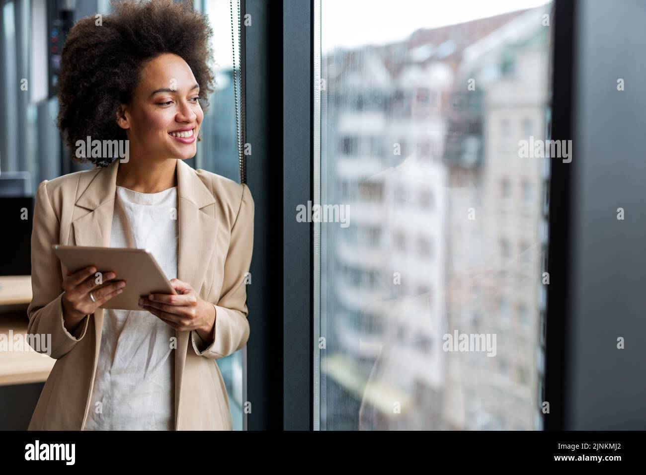 Bonne femme d'affaires responsable, avec une tablette et travaillant dans un bureau moderne Banque D'Images
