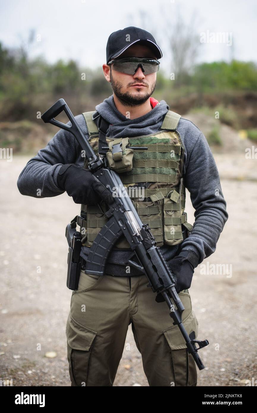 Un soldat de l'armée tisse avec une mitrailleuse dans la forêt. Entraînement de combat militaire en plein air nature Banque D'Images