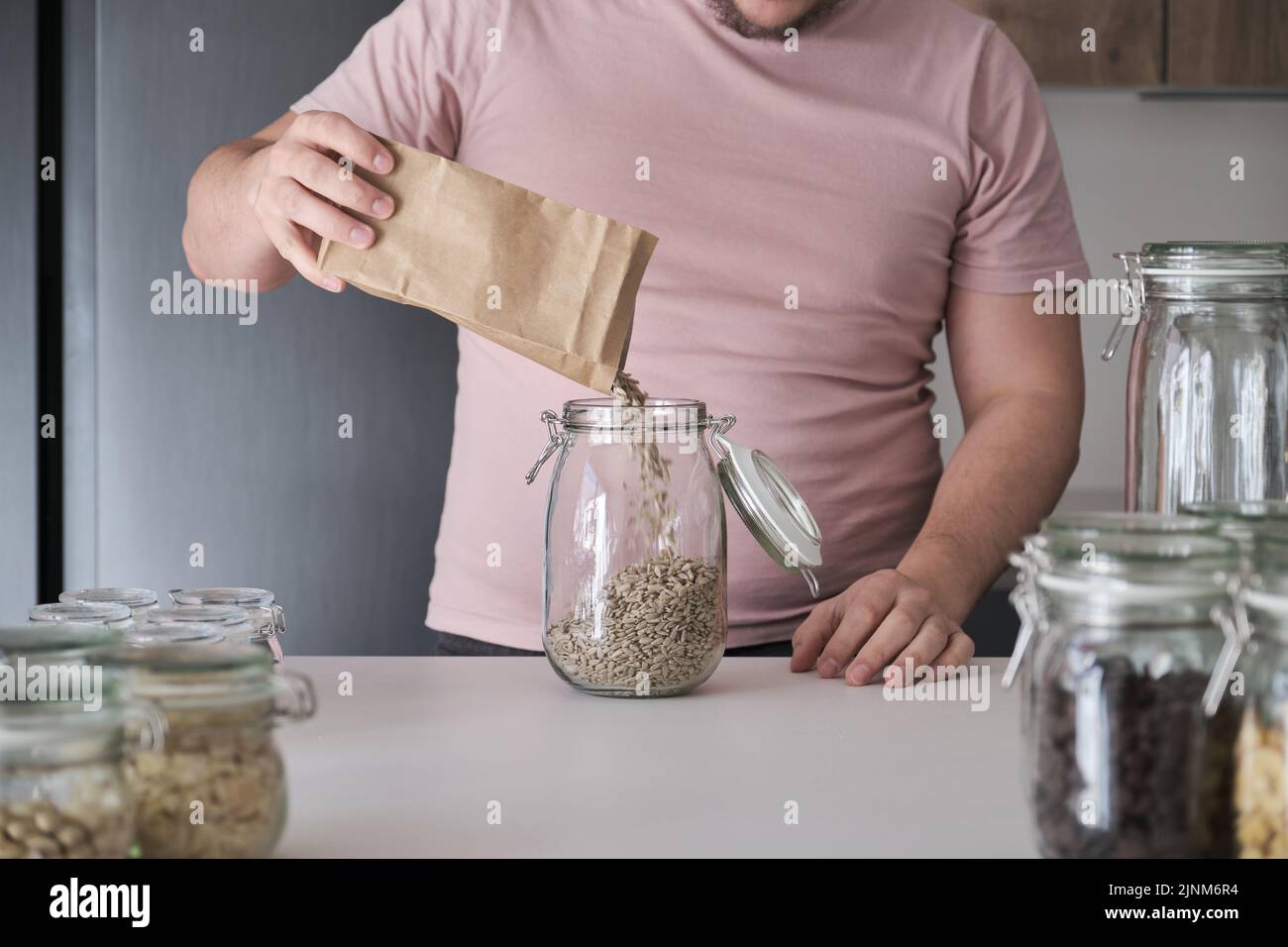 latins méconnaissables remplissant un pot de graines de tournesol pelées. Banque D'Images