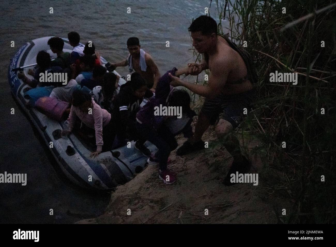 Les passeurs aident les enfants migrants non accompagnés à descendre d'un radeau après les avoir acheminés à travers le fleuve Rio Grande vers les États-Unis à partir du Mexique, à Rome, au Texas, aux États-Unis et au 11 août 2022. REUTERS/adrees Latif Banque D'Images