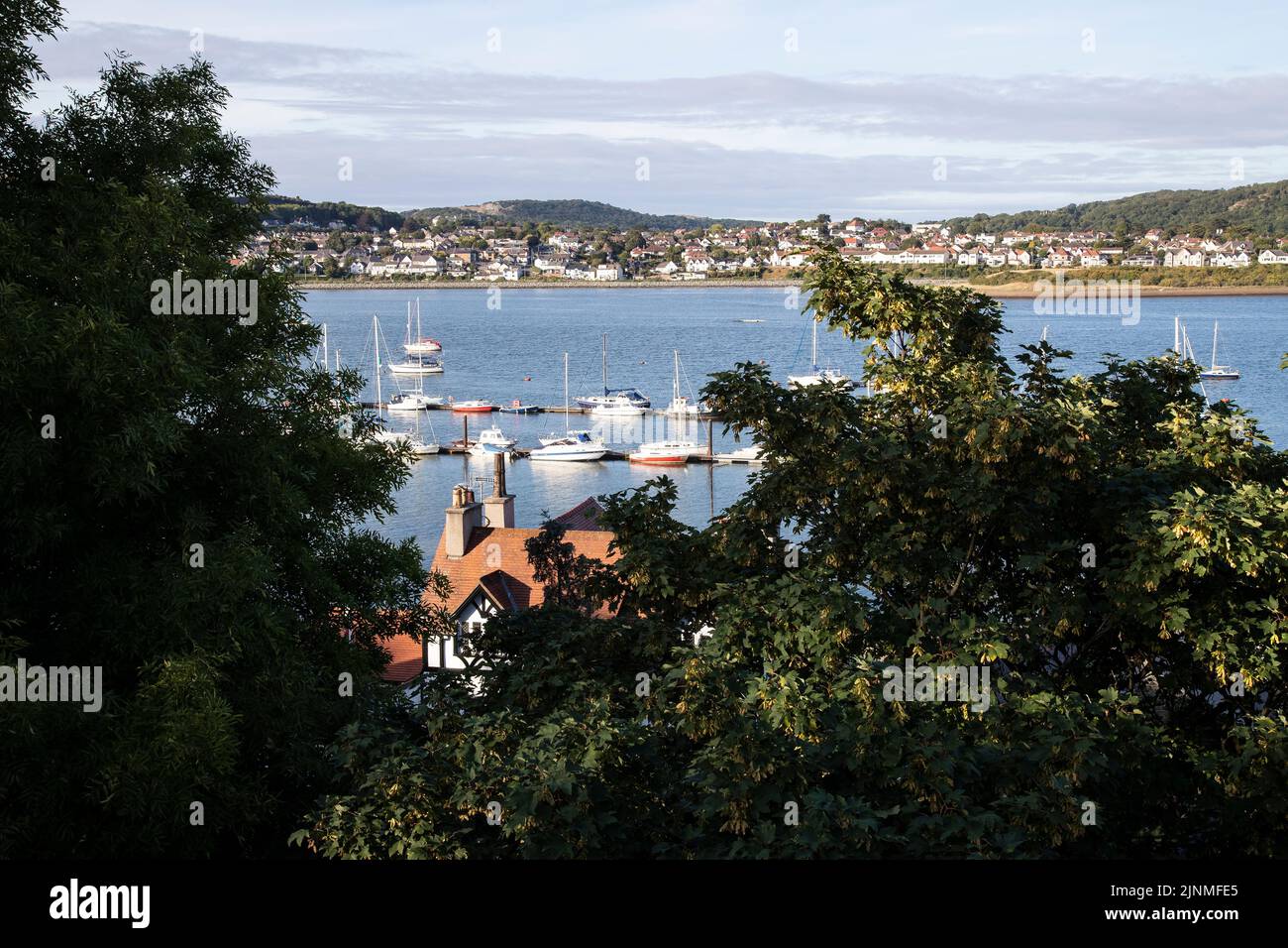 Vue d'été depuis les remparts de Conwy, dans le nord du pays de Galles, surplombant les bateaux amarrés sur l'estuaire de la rivière Conwy, avec Deganwy Town au loin Banque D'Images