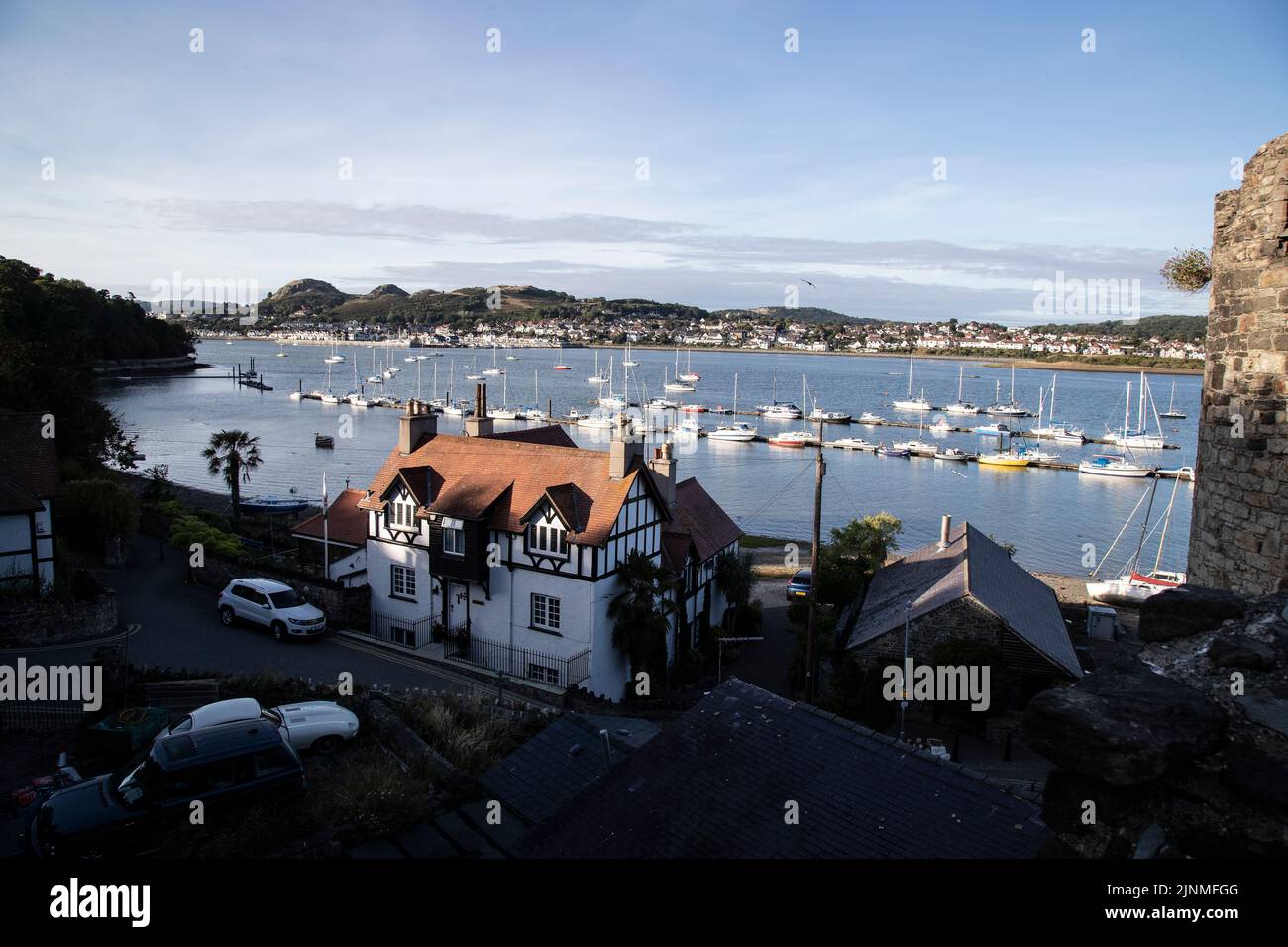 Vue d'été depuis les remparts de Conwy, dans le nord du pays de Galles, surplombant les bateaux amarrés sur l'estuaire de la rivière Conwy, avec Deganwy Town au loin Banque D'Images