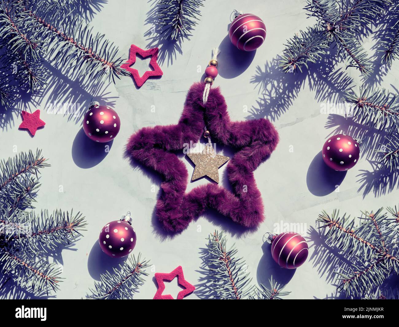 Toile de fond de Noël avec couronne de Noël en fausse fourrure et jouets à bulles rouges à pois. Image teintée, couleur verte bordeaux. Banque D'Images