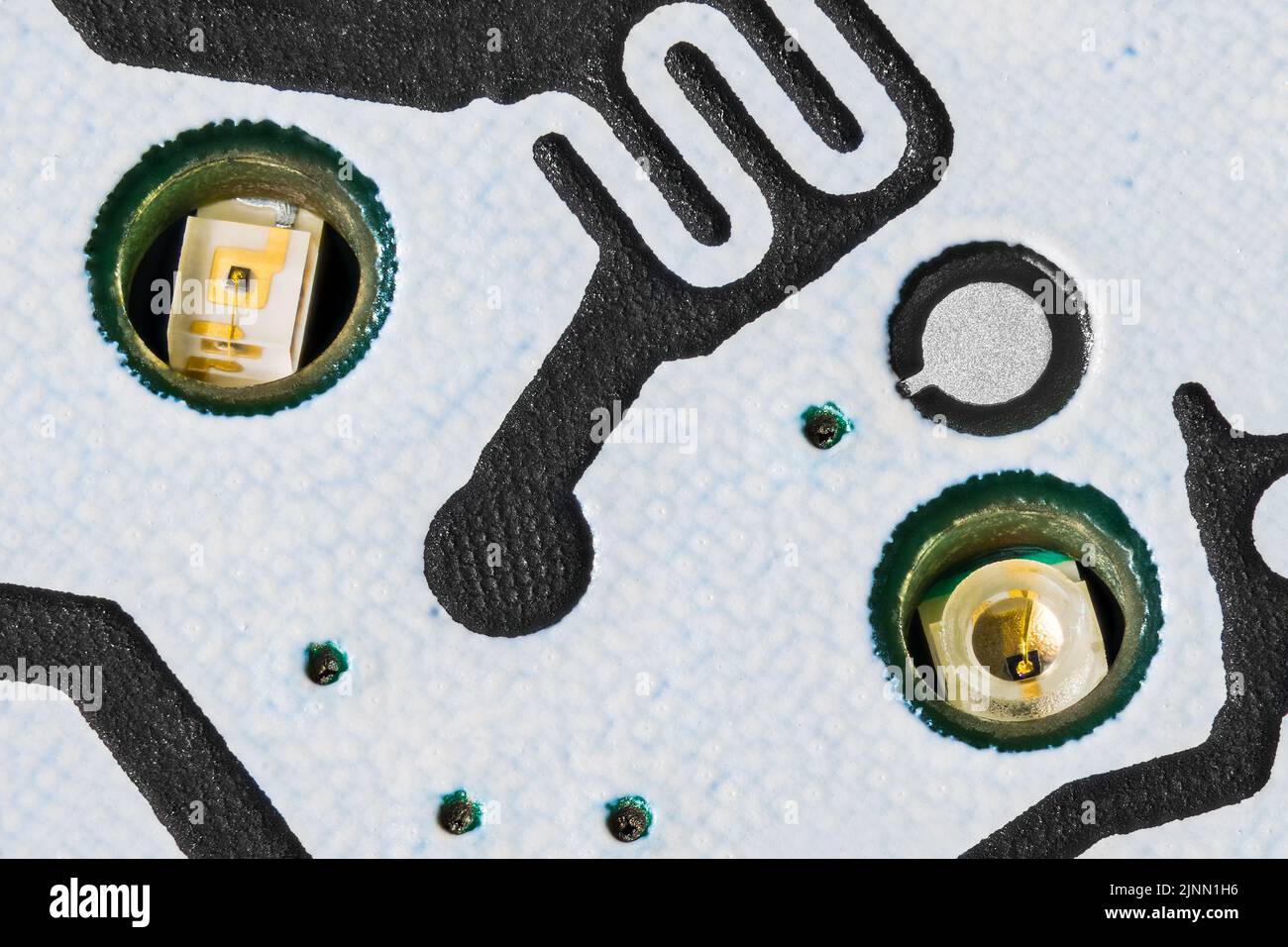 Gros plan de petites diodes LED à l'intérieur de la carte de circuit imprimé blanche. Sources électroniques d'émission de lumière pour le rétroéclairage des touches du clavier du téléphone mobile sur la carte de circuit imprimé. Banque D'Images