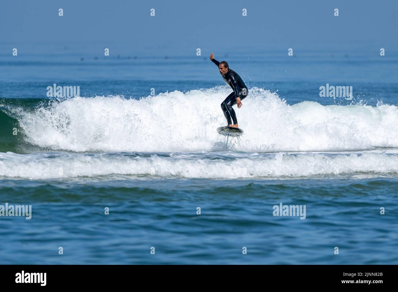 Un homme d'âge moyen faisant du surf en papier ou du surf en hydroglisseur dans la mer, par une journée ensoleillée. Banque D'Images
