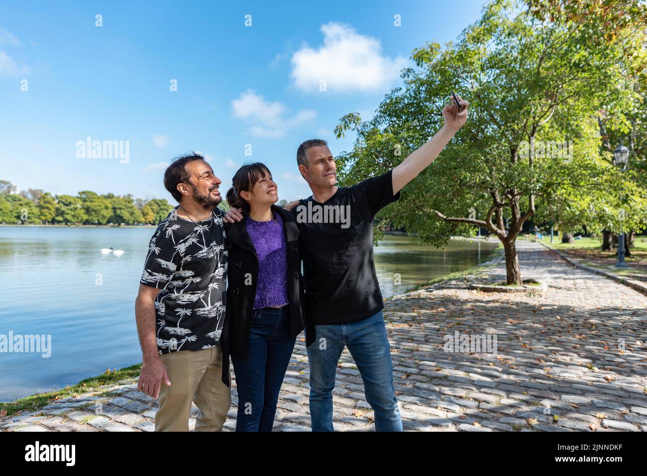 Un groupe d'amis prenant des selfies à l'extérieur Banque D'Images