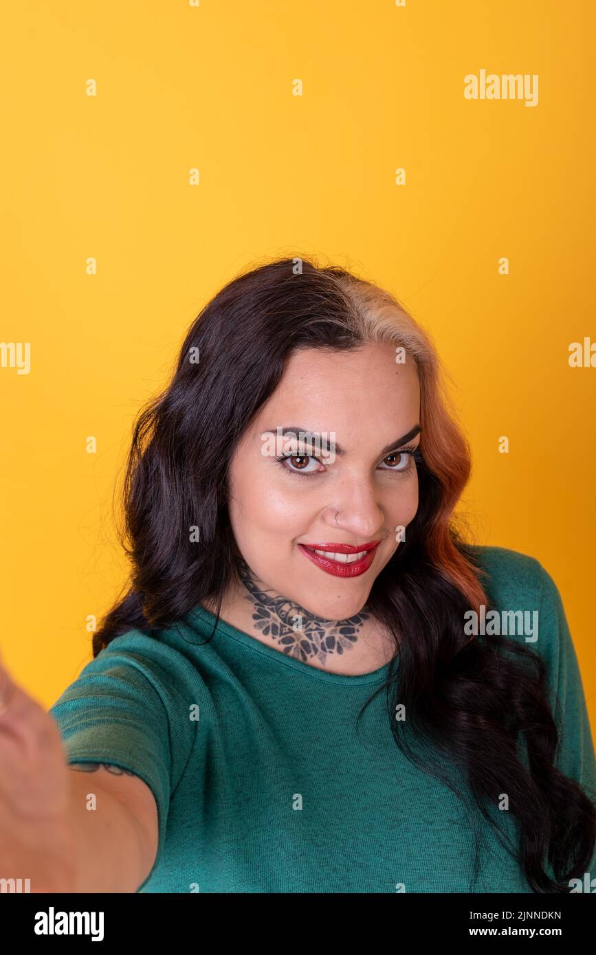 Portrait d'une femme attrayante faisant un selfie sur fond jaune Banque D'Images