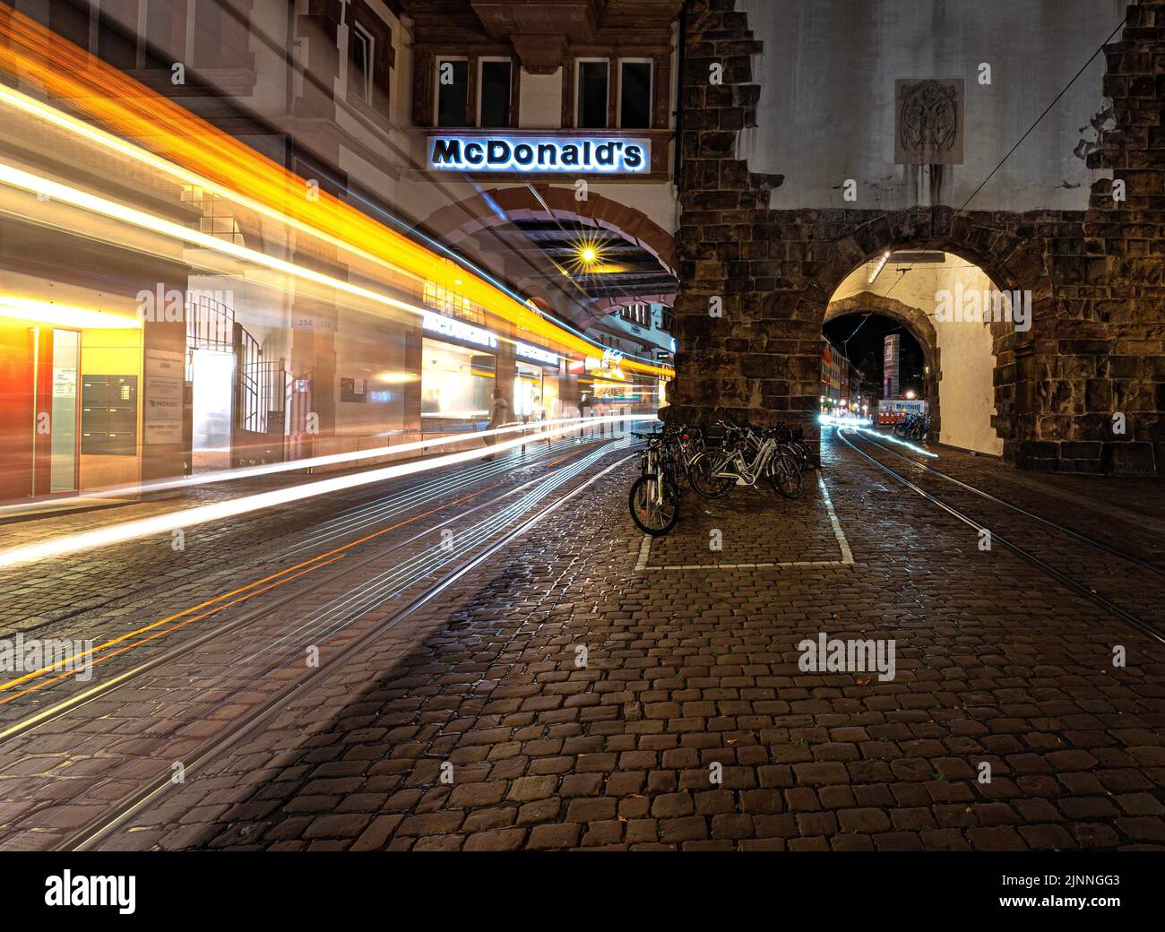 Longue exposition d'un tramway dans le centre-ville de Fribourg la nuit, Fribourg, Allemagne Banque D'Images