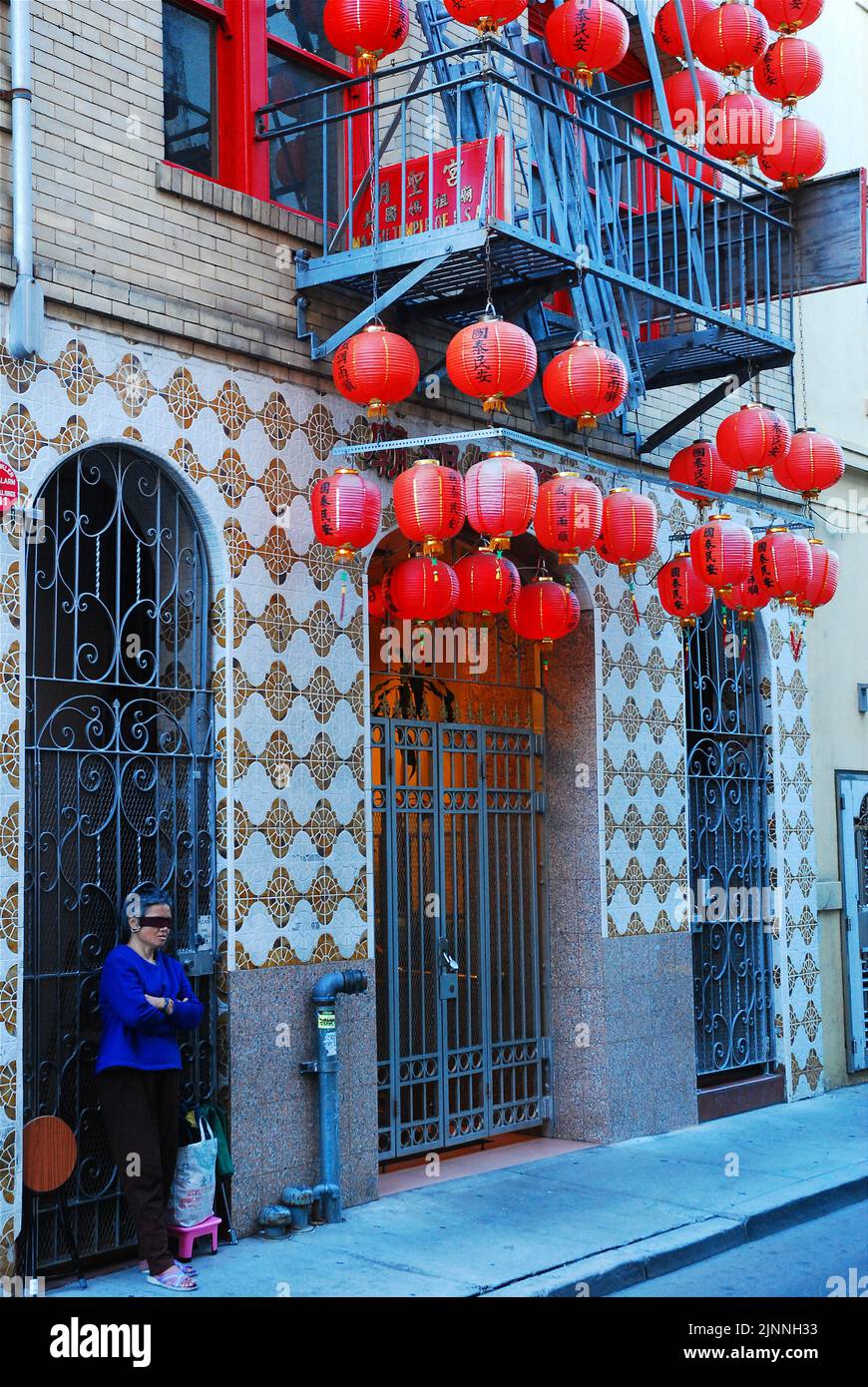 Une femme âgée bandée se tient à l'entrée du temple taoïste Ma Tsu à Chinatown, à San Francisco, dans le cadre d'un rituel religieux Banque D'Images